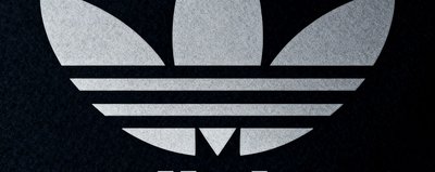 阿迪达斯品牌logo三条纹标识，灰白色调与深色背景形成对比
